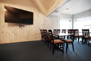 Sala de conferencias con mesa, sillas y TV de pantalla plana en Napoli Resturant & Hotell AS en Sandnessjøen