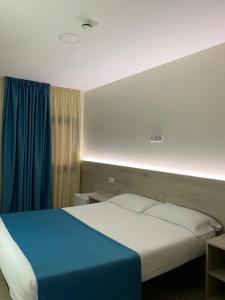 a bedroom with a large bed with a blue blanket at Solesperit in Lloret de Mar