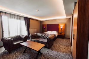 a hotel room with a bed and a couch and a table at Business Palas Otel in Kocaeli +47 photos