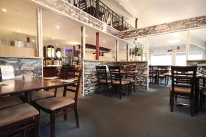 une salle à manger avec des tables et des chaises en bois dans l'établissement Napoli Resturant & Hotell AS, à Sandnessjøen