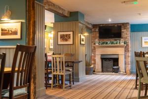 a living room with a table and a fireplace at Cross Keys by Chef & Brewer Collection in Nunthorpe