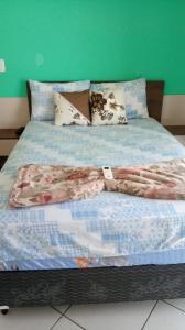 een bed met een deken erop bij Pousada do sol in Torres