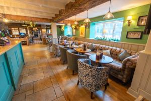 a restaurant with tables and chairs and a couch at Cross Keys by Chef & Brewer Collection in Nunthorpe