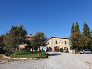 a large stone house with a car parked in the driveway at Podere il Poggio in Asciano