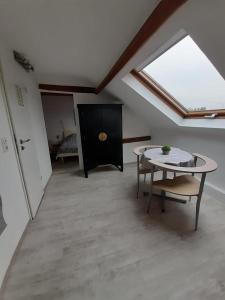 a attic room with a table and a bed at Studio Apartment in Alsdorf