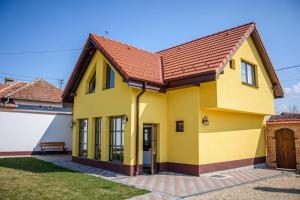 une maison jaune avec un toit rouge dans l'établissement Conacul lui Radu, à Făgăraş