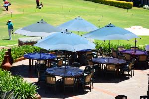 a group of tables and chairs with umbrellas at Windsor Golf Hotel & Country Club in Nairobi