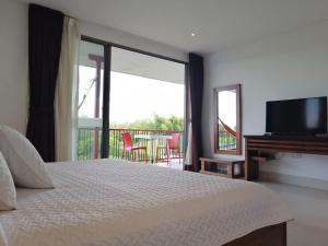 a bedroom with a bed and a television and a balcony at Finca Hotel la Manuela in Armenia +71 photos