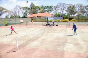 a group of people playing tennis on a tennis court at Windsor Golf Hotel & Country Club in Nairobi