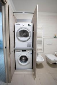 a bathroom with a washing machine and a toilet at Perla delle Dolomiti in Andalo