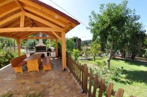 a wooden gazebo with a picnic table in a garden at SPITI MAGDALINI in Agios Georgios Pagon