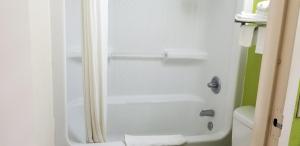 a bathroom with a shower with a white tub at Super 8 by Wyndham Ruther Glen Kings Dominion Area in Ruther Glen