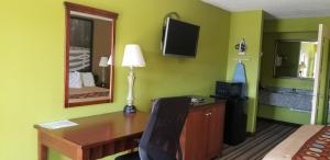 een hotelkamer met een bureau en een slaapkamer bij Super 8 by Wyndham Ruther Glen Kings Dominion Area in Ruther Glen