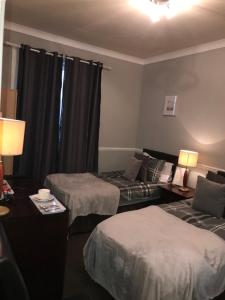 une chambre d'hôtel avec deux lits et un canapé dans l'établissement The Ocean Inn, à Édimbourg