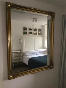 espejo que refleja una cama en un dormitorio en Fabulous Apartment in Historic House in St Aubin, en Saint Aubin