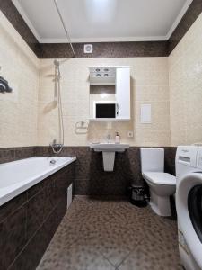 チェルニーヒウにあるChernigov City Apartments na Peremohyのバスルーム(シンク、バスタブ、トイレ付)