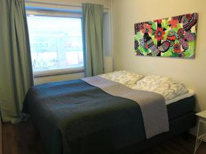 a bedroom with a bed with a painting on the wall at Feels like Arctic City in Rovaniemi