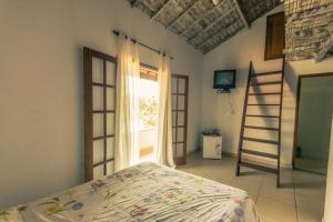 1 dormitorio con cama, escalera y ventana en La Tana del Tano Guest House, en Búzios