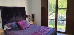 Un dormitorio con una cama con sábanas moradas y una ventana en Casablanca, House Near Benidorm, en Finestrat