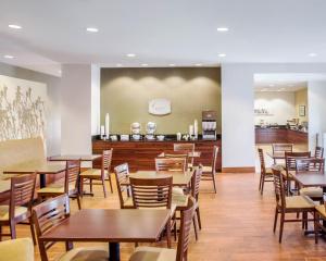 a dining room with wooden tables and chairs at Sleep Inn & Suites Parkersburg in Parkersburg