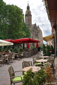 a patio with tables and chairs and a clock tower at LUX & Comfort in Košice