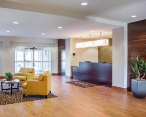 an office lobby with a yellow couch and a table at Sleep Inn & Suites Parkersburg in Parkersburg