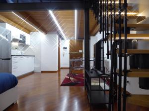 a living room with a staircase and a kitchen at Giudei House Suite Bologna in Bologna
