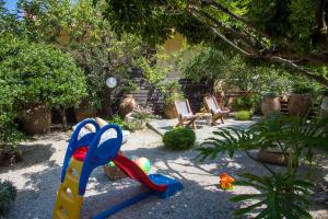 einen Garten mit Spielplatz mit Plastikspielzeug in der Unterkunft Evangelos Apartments in Platanias