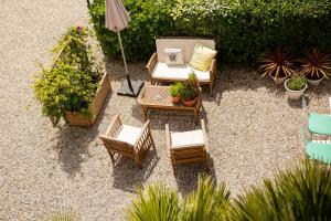 einen Blick über eine Terrasse mit Stühlen und einem Sonnenschirm in der Unterkunft Hôtel Du Soleil in Saint-Raphaël