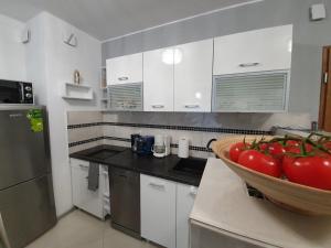 una cocina con un tazón de tomates en una barra en DWIE SOSNY - Apartament Morski Kryształ - SAUNA, JACUZZI, SIŁOWNIA, BAWIALNIA - 365PAM, en Ustronie Morskie