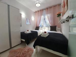 Un dormitorio con dos camas y una ventana. en DWIE SOSNY - Apartament Morski Kryształ - SAUNA, JACUZZI, SIŁOWNIA, BAWIALNIA - 365PAM, en Ustronie Morskie 24 fotos más