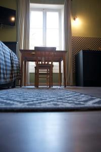 a bedroom with a desk and a chair in front of a window at Le 110, un grand studio 2 étoiles, pour tout faire à pied in Aix-les-Bains