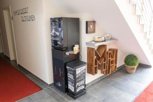 a room with a black refrigerator next to a wall at Mey Hotel in Osnabrück