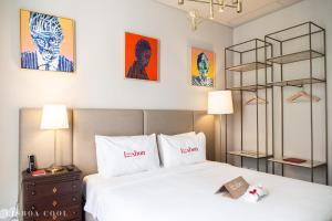a bedroom with a white bed and some paintings at Dare Lisbon House in Lisbon