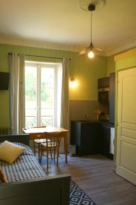 a living room with a table and a kitchen at Le 110, un grand studio 2 étoiles, pour tout faire à pied in Aix-les-Bains