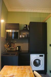 a kitchen with a washing machine and a microwave at Le 110, un grand studio 2 étoiles, pour tout faire à pied in Aix-les-Bains