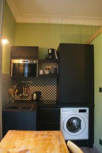 a kitchen with a washing machine and a microwave at Le 110, un grand studio 2 étoiles, pour tout faire à pied in Aix-les-Bains +12 photos
