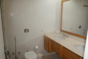 W łazience znajduje się umywalka, toaleta i lustro. w obiekcie Pousada Brig Maresias w mieście Maresias