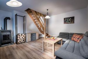 a living room with a couch and a staircase at Chata pod lesom Kvačany in Kvačany +27 photos