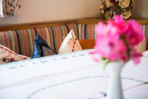 Una cama con un jarrón con flores rosas. en Ferienwohnung Cuntera, en Curaglia