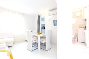 een witte kamer met een witte tafel en stoelen bij One bedroom house at Skrpcici 500 m away from the beach with enclosed garden and wifi in Skrbčići