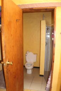 a bathroom with a toilet and a door open at Hotel Paraiso del Oso in Cerocahu&iacute;
