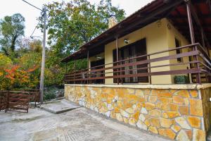 a house with a stone wall next to a building at The Theater of Dreams in Synikia Mesi Trikalon