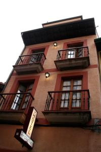 un edificio alto con ventanas y balcones. en Pensión Argüelles, en Ribadesella