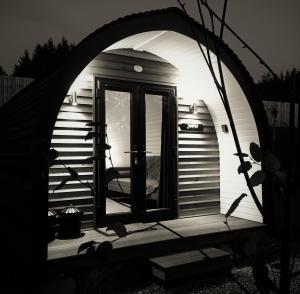 an arched entrance to a tiny house with a door at Tomatin Glamping Pods in Inverness