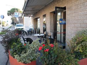 a building with plants and flowers in front of a restaurant at Caffetteria dell'Angolo in Borghetto Secondo