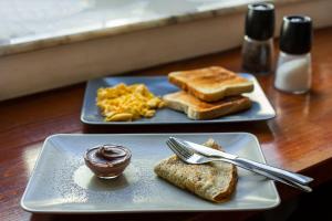 Dos platos de desayuno con tostadas y almíbar. en Rossio Hostel, en Lisboa
