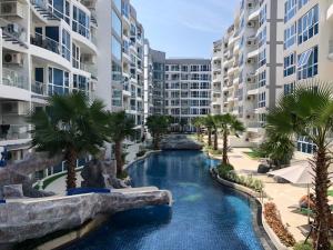 an image of a swimming pool in a resort with palm trees at Luxury Business Suits in Grand Avenue by Pattaya City Estates in Pattaya Central