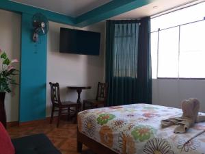 钦博特Hotel Camino Real的一间卧室，配有一张床、一台电视和一张桌子