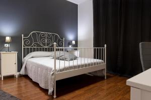 a bedroom with a white bed and black walls at Villa Noemi Bed&Breakfast in Pisa